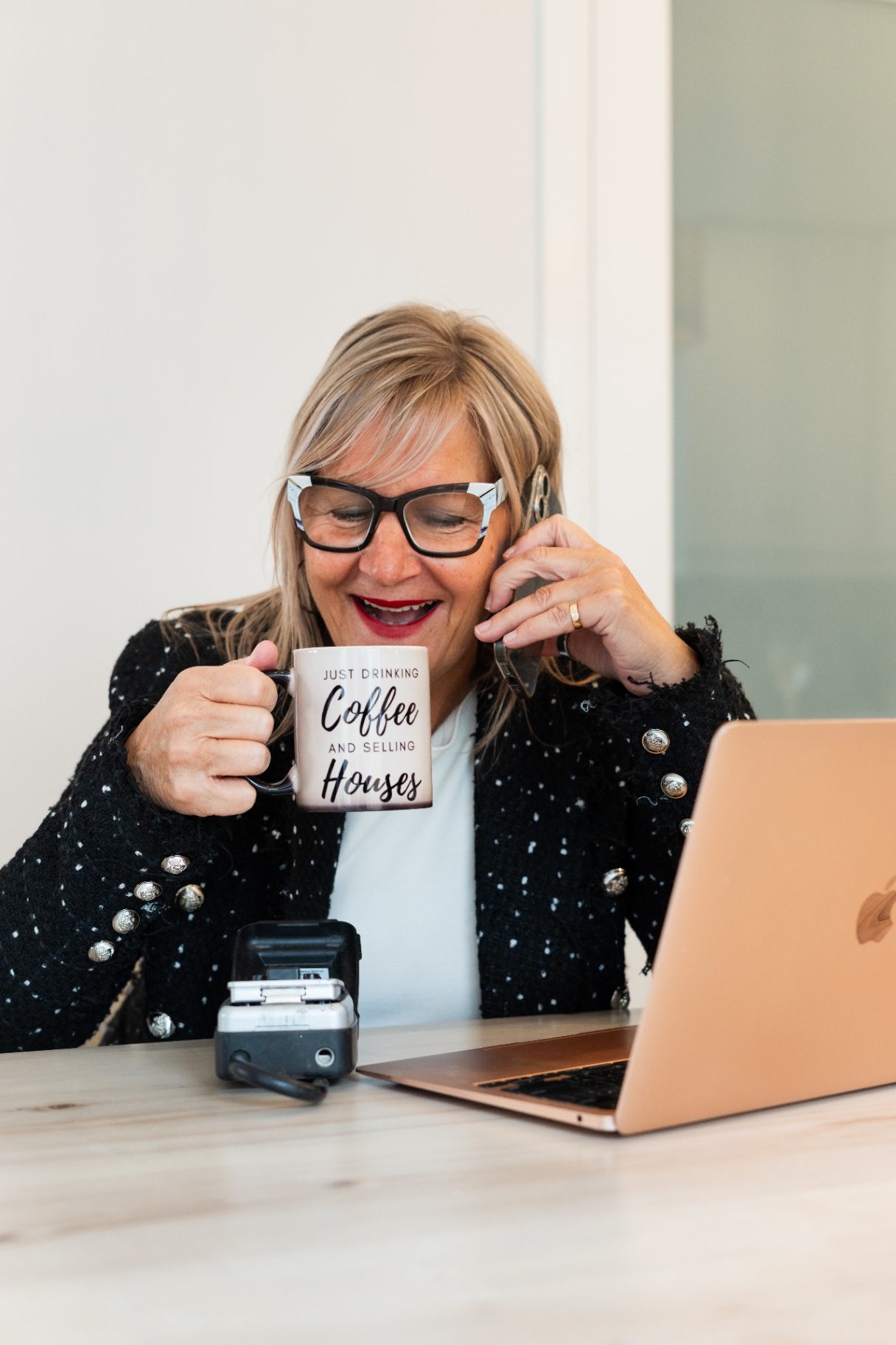 Karen Roy on the phone with a client over coffee